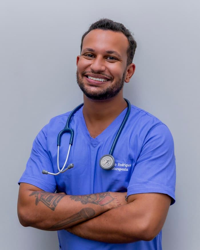 Profissional sorridente de uniforme azul com estetoscópio