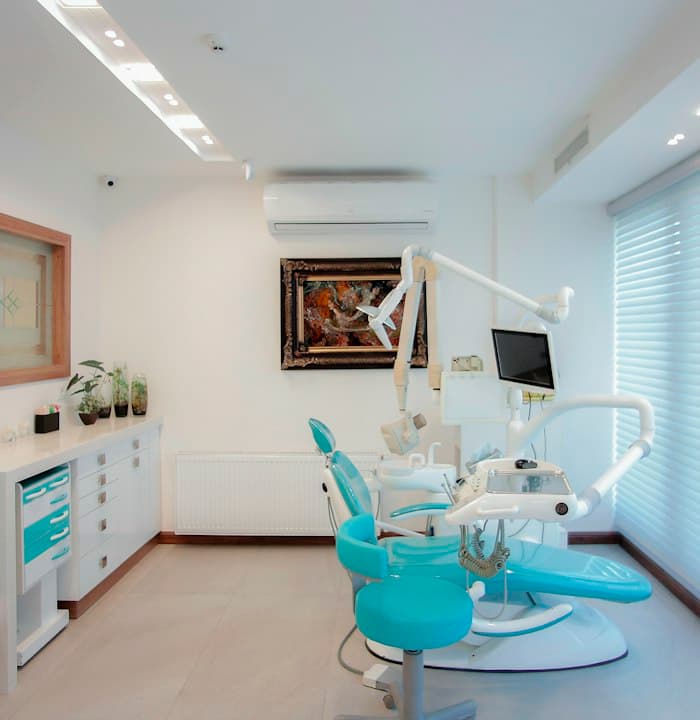 Consultório odontológico branco com cadeira azul-clara
