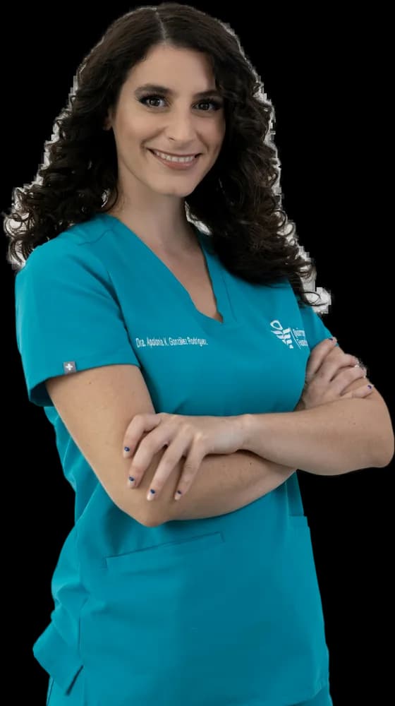 Profissional de saúde sorrindo, de braços cruzados, com uniforme verde-azulado