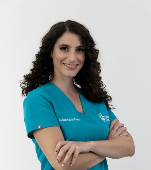 Retrato da Dra. Marina Ferreira sorrindo, com uniforme clínico